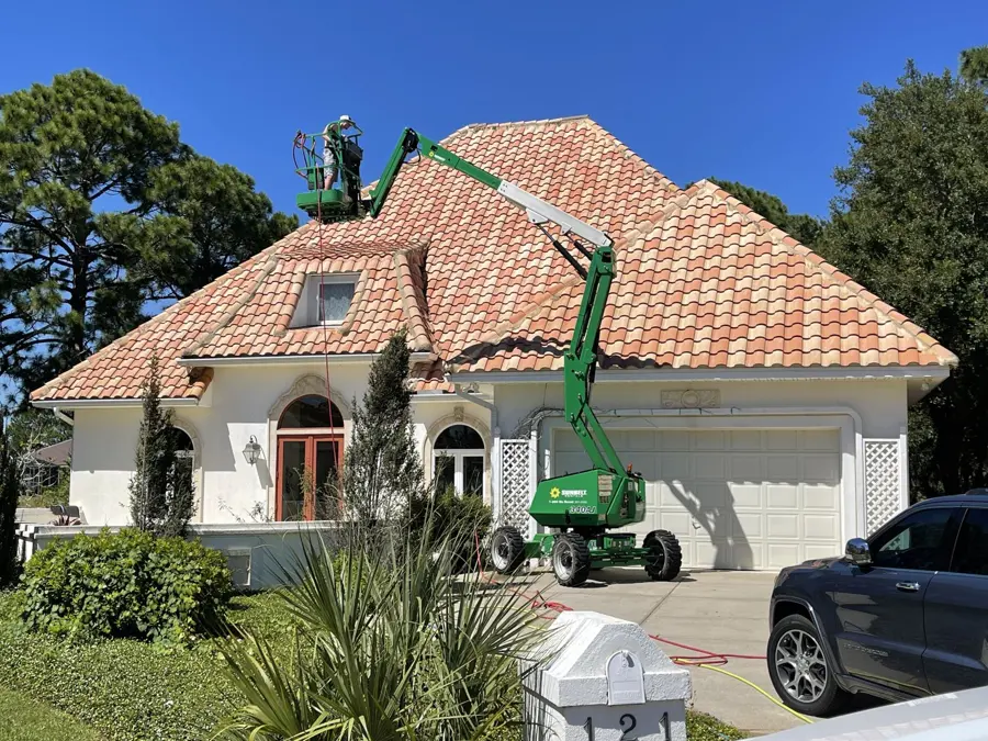 Tile roof being cleaned from a lift